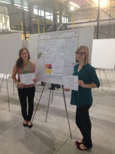 Kristy Gutchess (right) and Shannon Garvin stand by their winning poster.